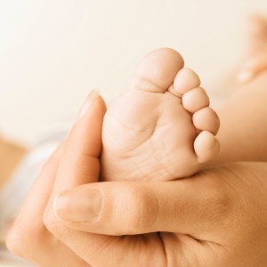 Close up of baby's foot in mother's hand